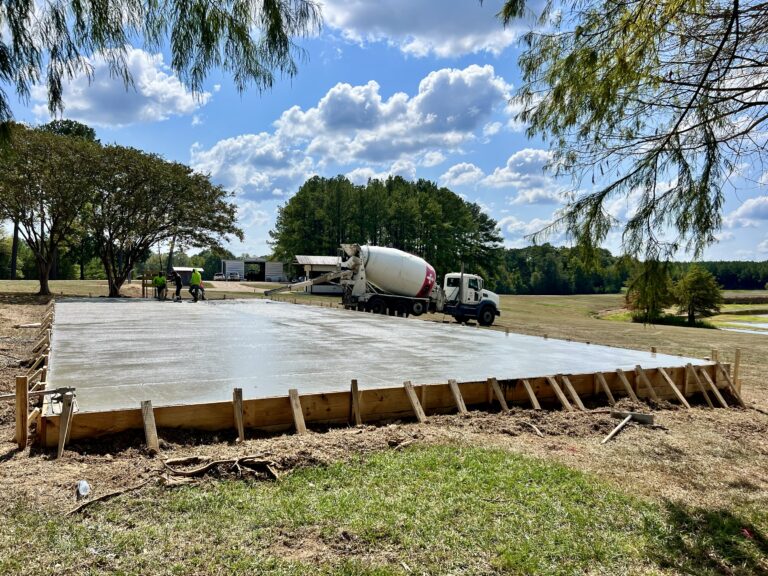 A foundation with a concrete mixing truck in the background.